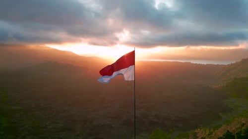 Incrível nascer do sol em glamping com a bandeira da Indonésia tremulando ao vento ao lado do vulcão Batur com