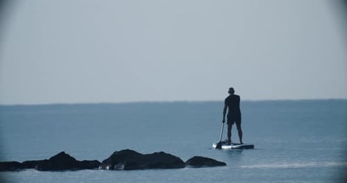 Paddle Boarding in the Sea a Man Rides a Board