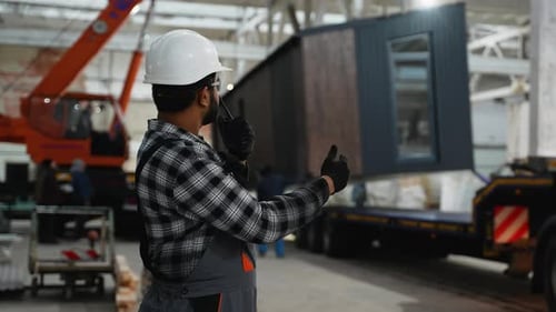 Indian Worker Supervising Modular Home Loading with Crane