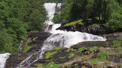 A beautiful waterfall in the Geiranger fjord, Norway. Turbulent white-water rushing down the rocks i