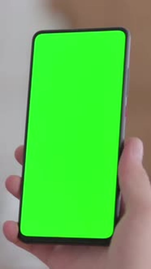 Close Up of Female Hand using Smartphone with Green Chroma Key Screen, vertical video