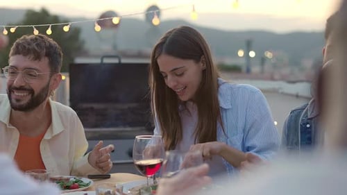 Young Group of Friends Having Barbecue Dinner Party at Terrace Rooftop in Summer