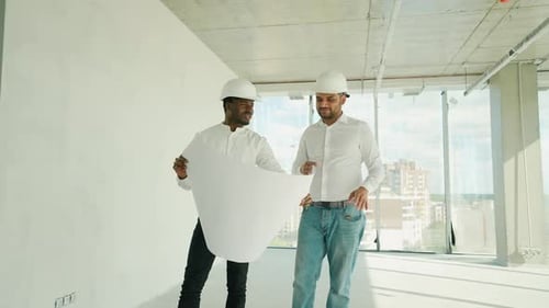 Multiethnischer Arbeiter und Ingenieur diskutieren über den Plan
