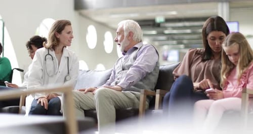Senior Male talking to Doctor in a crowded hospital waiting room
