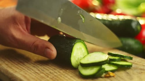 Slowmotion Video of Cutting a Cucumber Into Rings with a Knife in the Kitchen