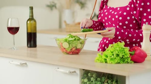 Woman Prepares Fresh Salad in Bright Kitchen
