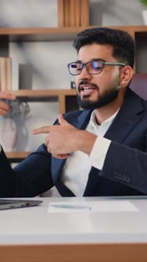 Gut aussehender indischer Geschäftsmann, Kundenbetreuer oder Verkäufer, der sich bei einem virtuellen Meeting unterhält