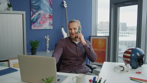 Smiling entrepreneur chatting smartphone explaining details at modern office workplace