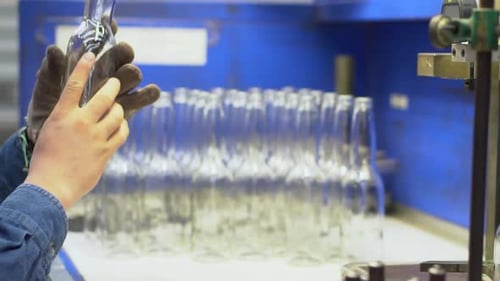 expert inspectant une bouteille en verre au ralenti dans une usine de bouteilles