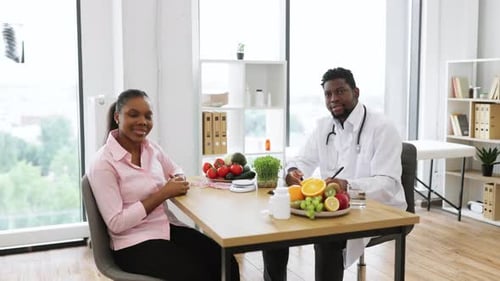 Doctor and Patient Give Thumbs Up at Appointment