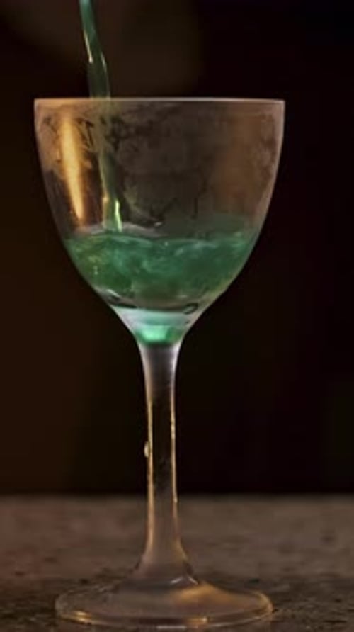 Wine Glass with Green Coctail on Black Background Stock Footage Close Up of a Hand Pouring Alcoholic