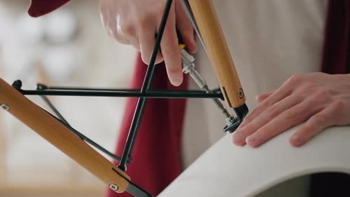 Hands Assemble Modern Chair with Screwdriver