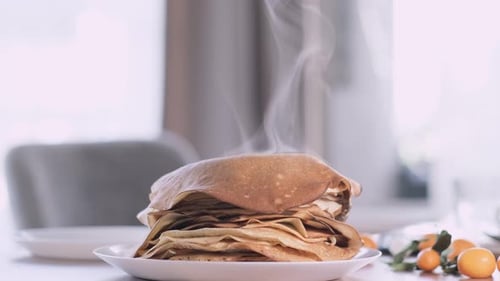 Hot Crepes Stacked on a Plate with Steam