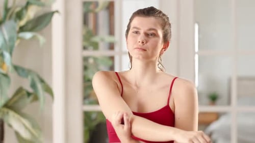 Woman Stretching Arm in Indoor Setting