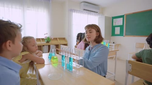 Adorable student learn with teacher in classroom at elementary school.