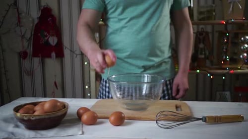 Man Cracking Eggs into Bowl for Cooking