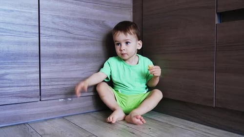 Happy Child Eating Snack in Kitchen