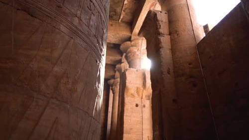 Nahaufnahme geschnitzter Säulen mit Hieroglyphe im ägyptischen Pyramidentempel mit mystischem Sonnenschein