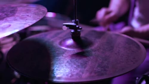 Closeup of Drum Cymbals Glowing Under Purple Stage Lights