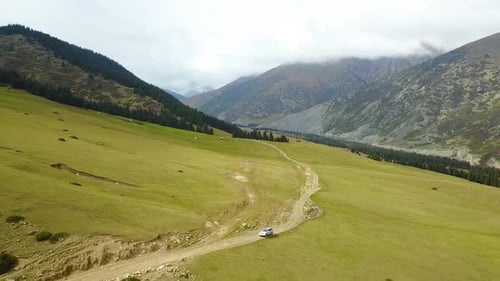 Car driving on the mountain meadow