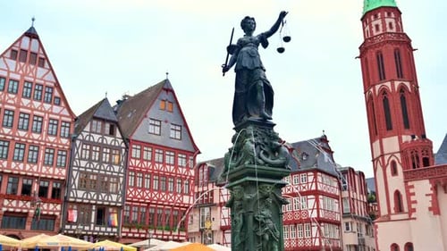 The Fountain Of Justice located in the Roemerberg, Frankfurt, Germany. Half-timbered buildings on th