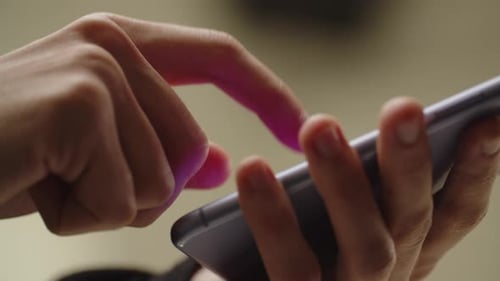 Person is Typing a Message on Smartphone Cropped View of a Man Holding Phone and Tapping on the