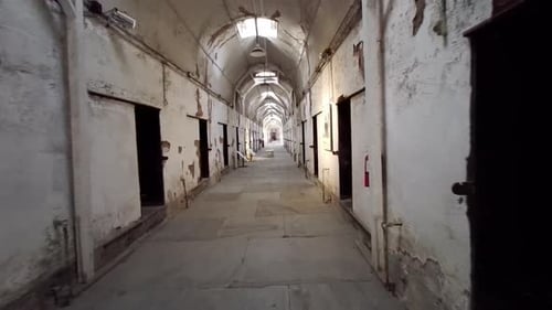 Moving shot of prison corridor past cells at Eastern State Penitentiary.