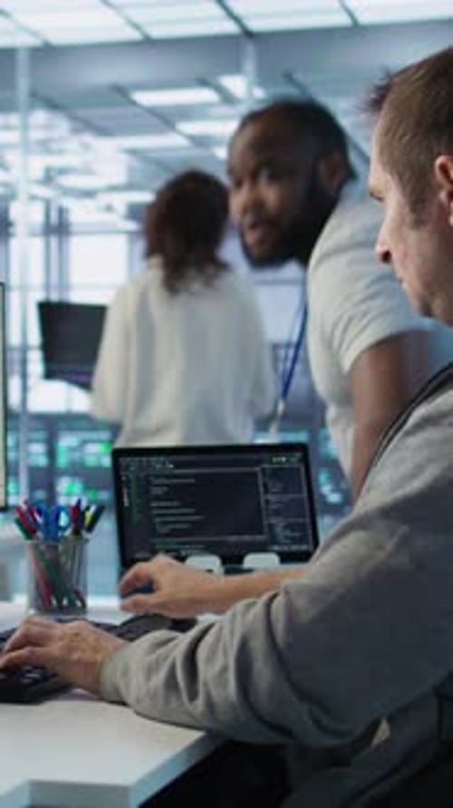 Programmer Requesting Help From Manager While Working on Computer in Data Center