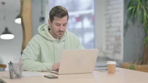 Young Adult Working on Laptop in Office