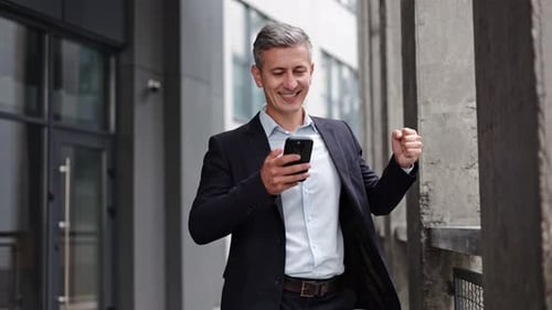 Businessman Receives Good News On Phone And Celebrates