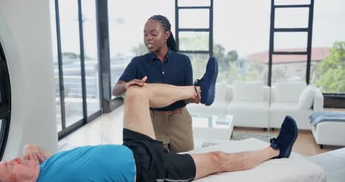 Therapist Stretching Senior Man's Leg