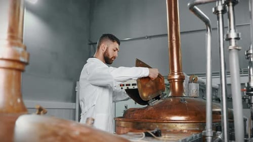 L'équipement traditionnel d'une brasserie moderne : un technologue contrôle le processus de brassage