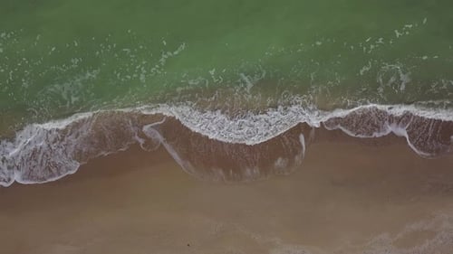 Aerial Top Down View of Tranquil Empty Beach Foamy Ocean Waves Washing Sand on Shore Sea Waves