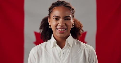 Young Adult Smiling in Front of Canada Flag