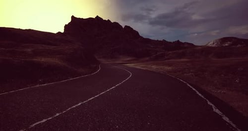 Winding Road Through a Mountainous Landscape at Dusk