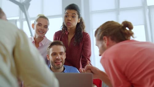 Creative People Working Together with Laptop in Modern Office. Excited Colleagues Discussing