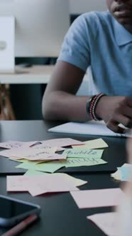 Étudiants interculturels apprenant le vocabulaire anglais avec des notes autocollantes