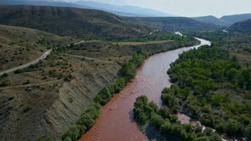Aerial footage of a river where the soil has turned red due to rain