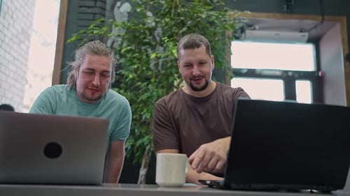 Two Laughing It Software Engineers Working on Project and Programming in Coffee Shop Successful