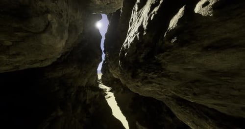 Bright Sunlight Filters Through a Narrow Rock Crevice in a Desert Landscape