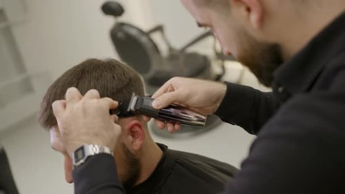 Bearded Man Getting Haircut at Barbershop