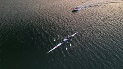 Luftaufnahme von zwei Rudererinnen in einem doppelten Rennboot mit synchronem Ruderschlag