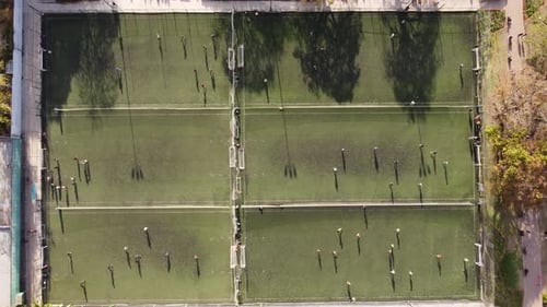 Aerial straight down shot of many soccer fields during training session in summer