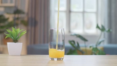Bright Orange Juice Being Poured into Glass
