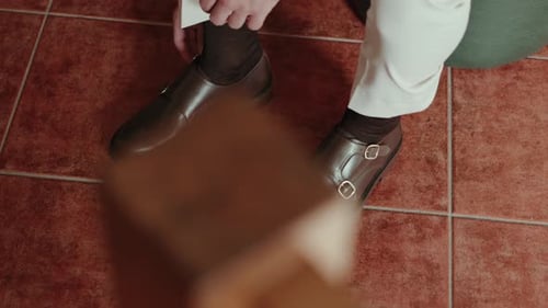 Adult man putting on his brown shoes