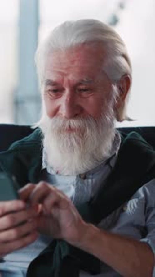 Senior Man Using Smartphone Indoors in Vertical Video