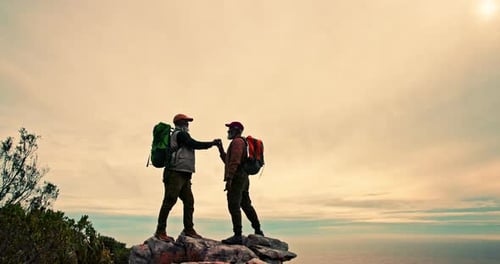 Mature man, friends and mountain with high five on cliff for teamwork, achievement