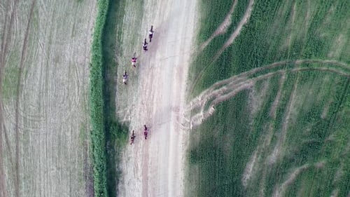 Horseback riding in a green Badlands terrain, aerial footage