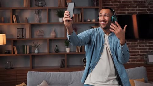 Man Dancing and Holding Phone in Living Room