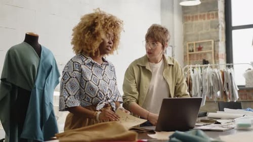 Fashion Designers Collaborating at a Worktable